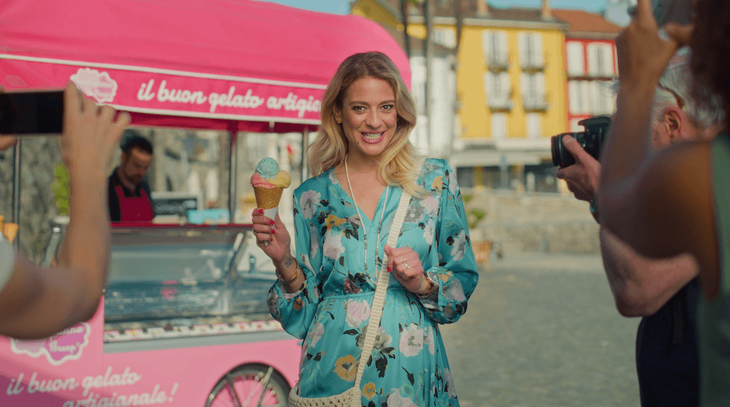 Frau mit Gelato vor pinkem Eiswagen wird fotografiert, Ascona